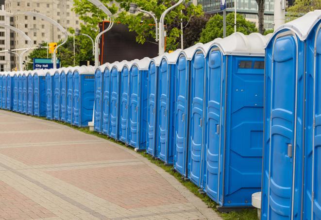 a row of portable restrooms at an outdoor special event, ready for use in Elizabeth